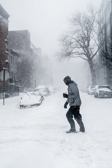 Person walking through a snowy city street.